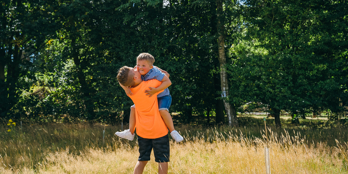 Dad picking up his son playfully .