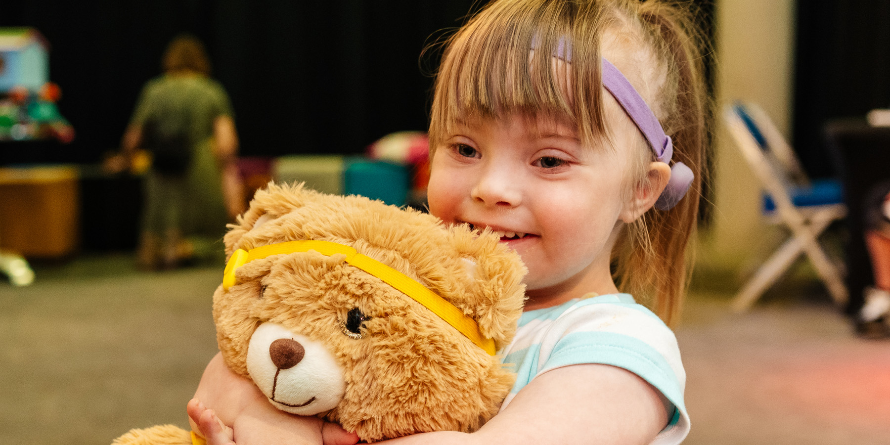 Girl with bear at the Bear Ear Clinic