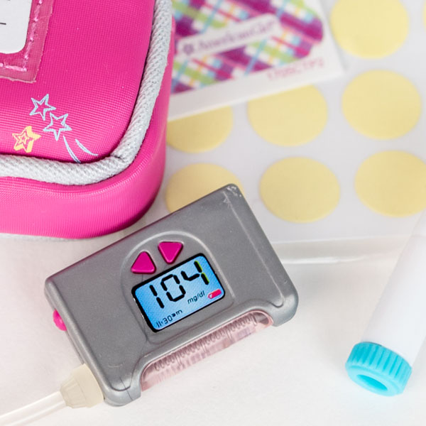 Close up of American Girl toy diabetes monitor in silver and pink.