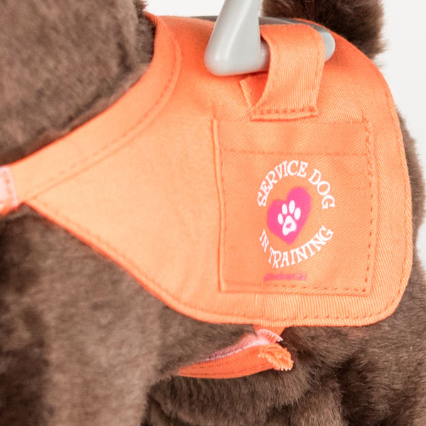 Close up of American Girl toy guide dog harness. Stitching on the harness reads 