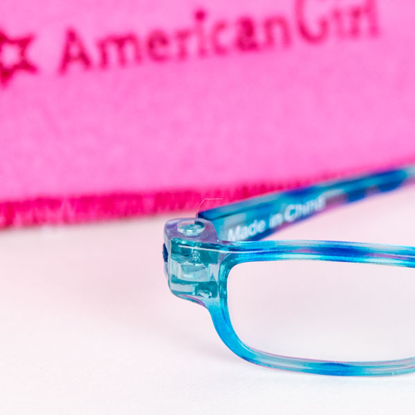 Close up of American Girls glasses in blue and pink glasses case in background.