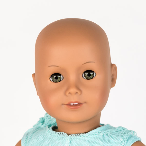 Close up of American Girl doll with no hair, blue eyes and blue lace dress.