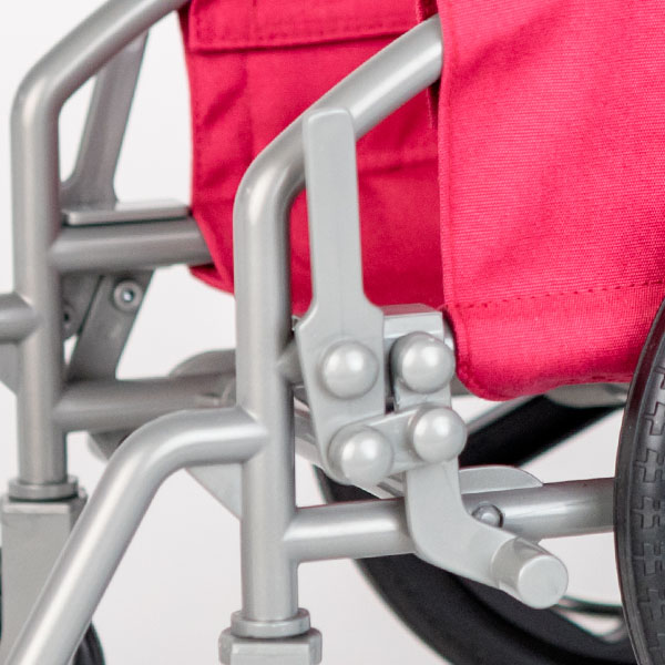 Close up of pink American Girl wheelchair showing break mechanism.