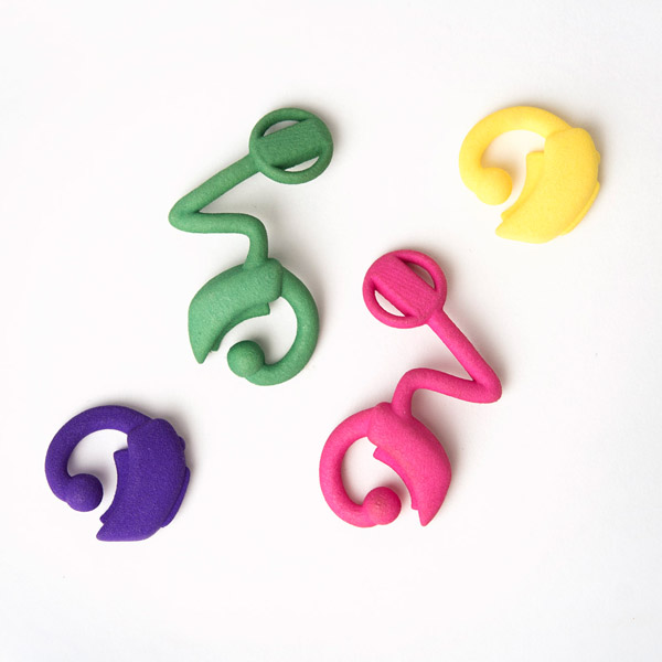 Group of 3D printed hearing aids and cochlear implants in green, purple, pink and yellow.