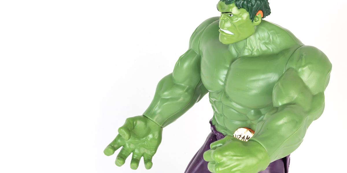 #ToyLikeMe makeover image showing Hulk toy with orange model hearing aid.