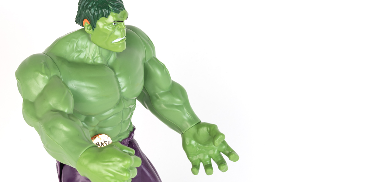 #ToyLikeMe makeover image showing Hulk toy with orange model hearing aid.