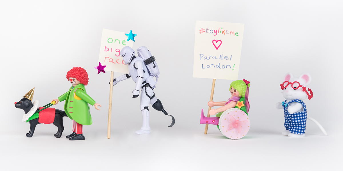 #ToyLikeMe makeover image showing a group of toys with various diff:abilities and carrying a sign which reads '#ToyLikeMe loves Parallel London, one big race,'