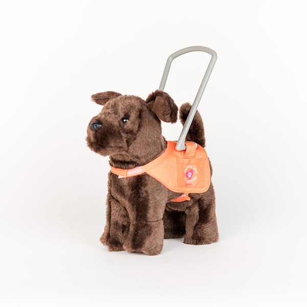 Image shows a plush guide dog. The dog is brown and has an orange and grey guide dog harness.