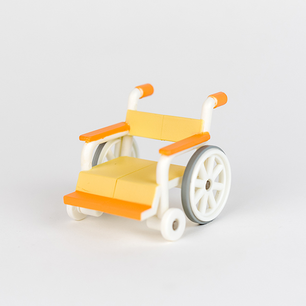 Image shows toy pink wheelchair.