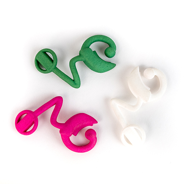 Image shows three 3D printed cochlear implants in pink, white and green.