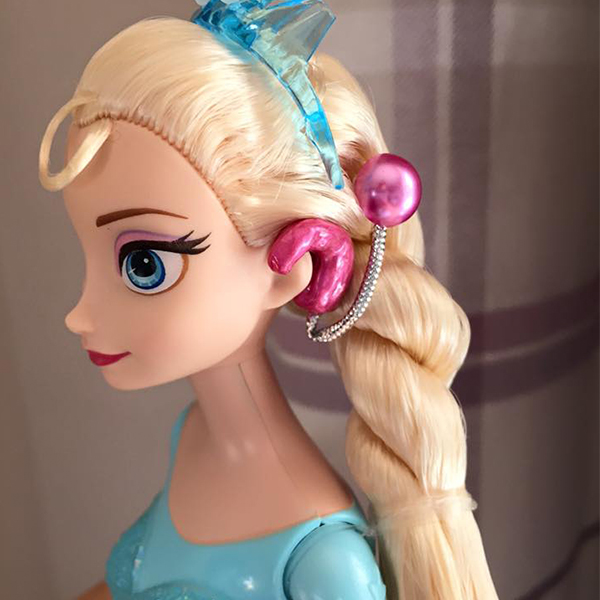 Community makeover image showing Elsa doll with model cochlear implant.