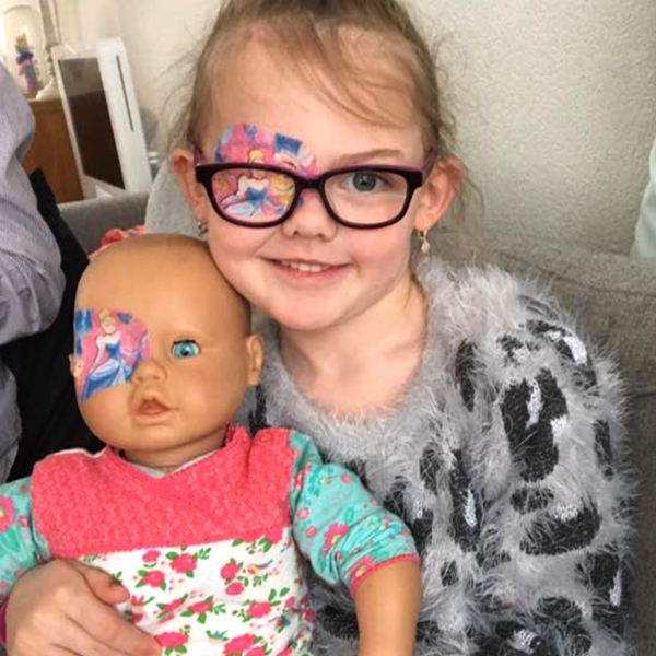 Community makeover image showing a girl and a baby doll. Both have matching eye patches.