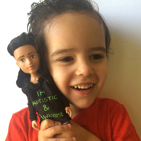 Community makeover image showing boy with doll. The doll has a t-shirt which reads 'I'm autistic and awesome'.
