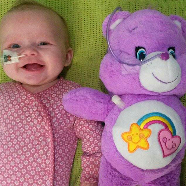 Community makeover image showing a baby and a teddy bear lying side by side. Both have nasal feeding tubes.