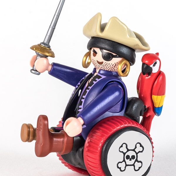 #ToyLikeMe makeover image of Playmobil pirage figure using a black and red wheelchair made of modelling clay.