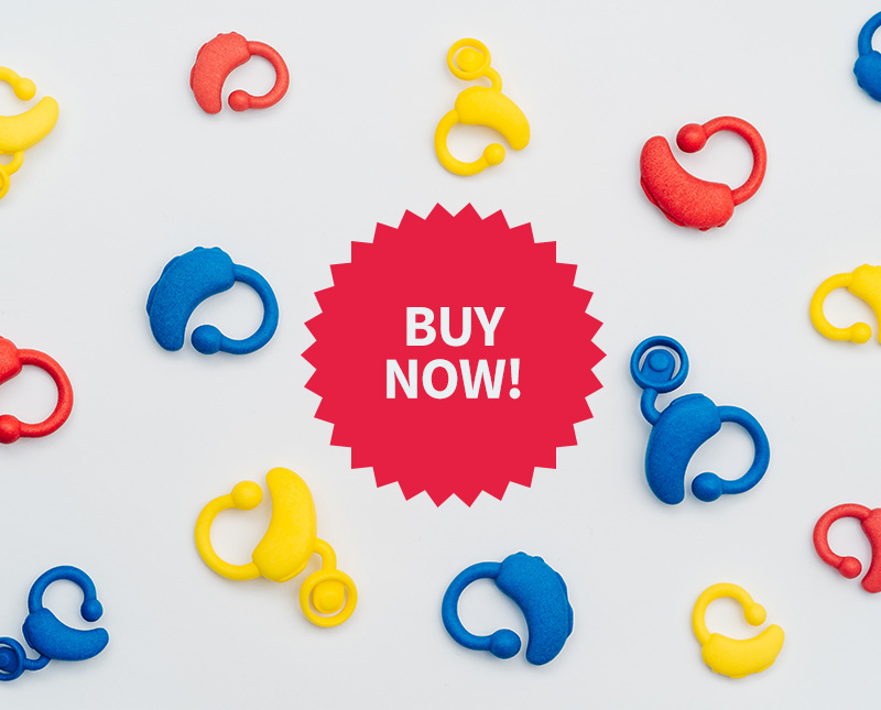 Image shows plastic toy hearing aids in red, yellowfins and blue and the text BUY NOW!