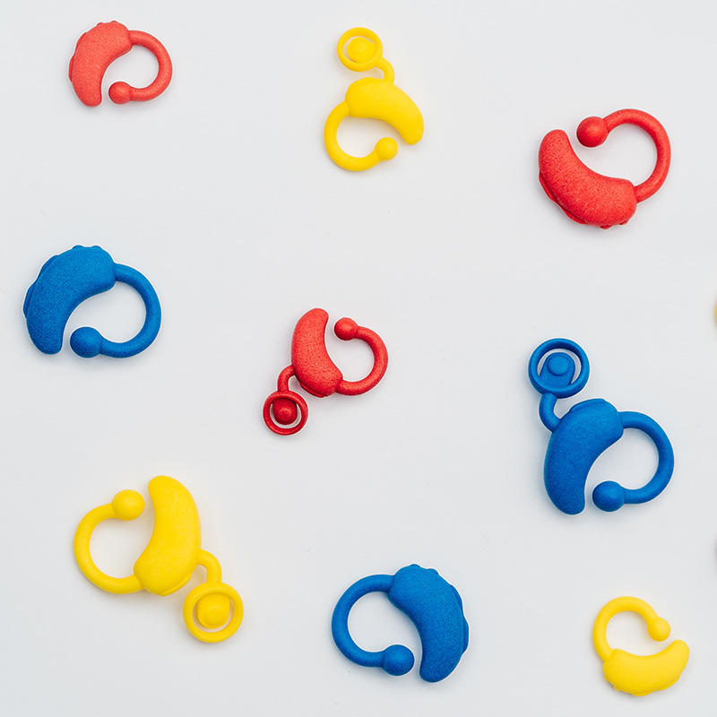Image shows red, blue and yellow toy cochlear implants and hearing aids